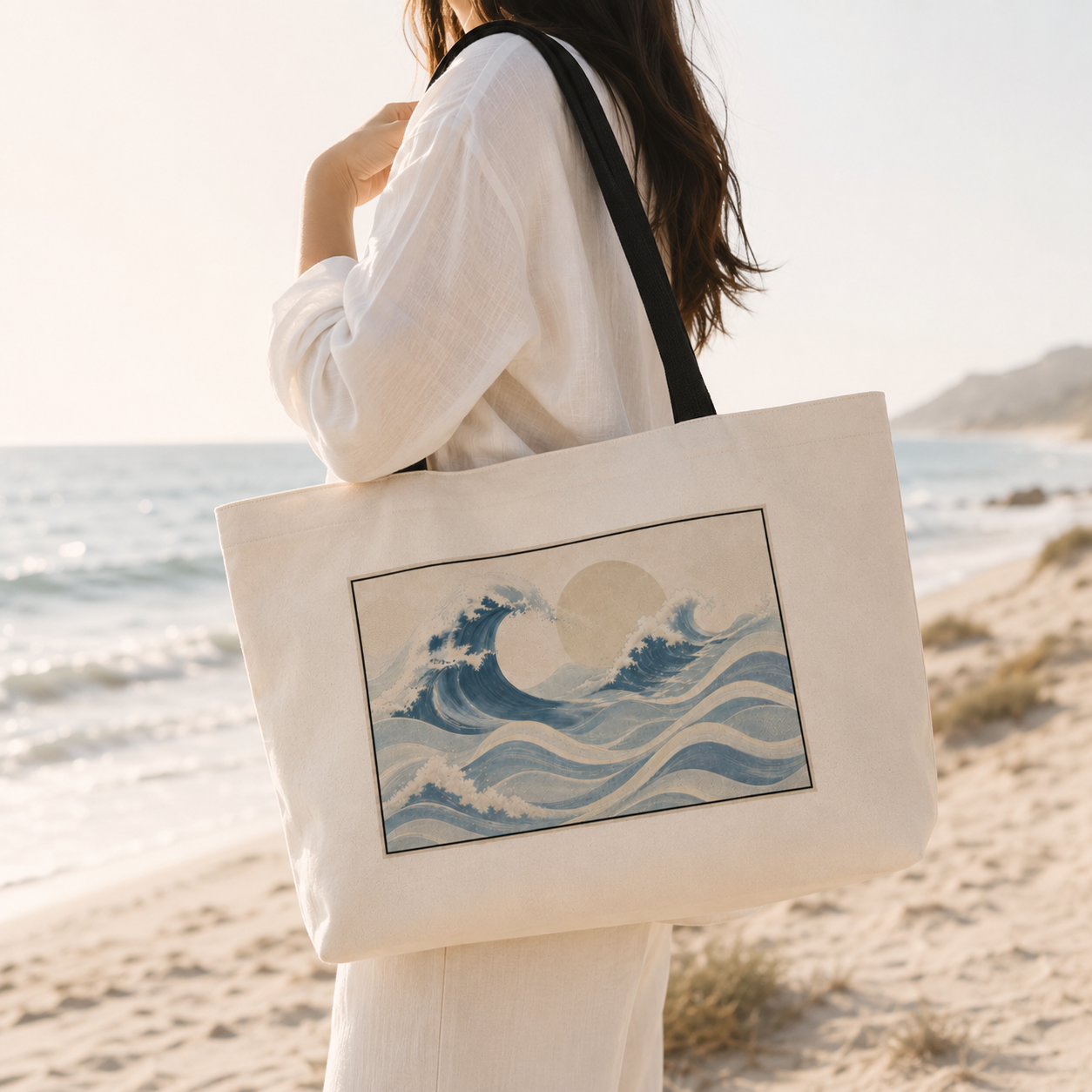 Person holding a tote bag with wave design on a beach