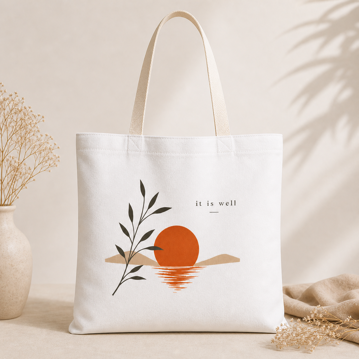 Tote bag with a sunset design and 'it is well' text on a neutral background