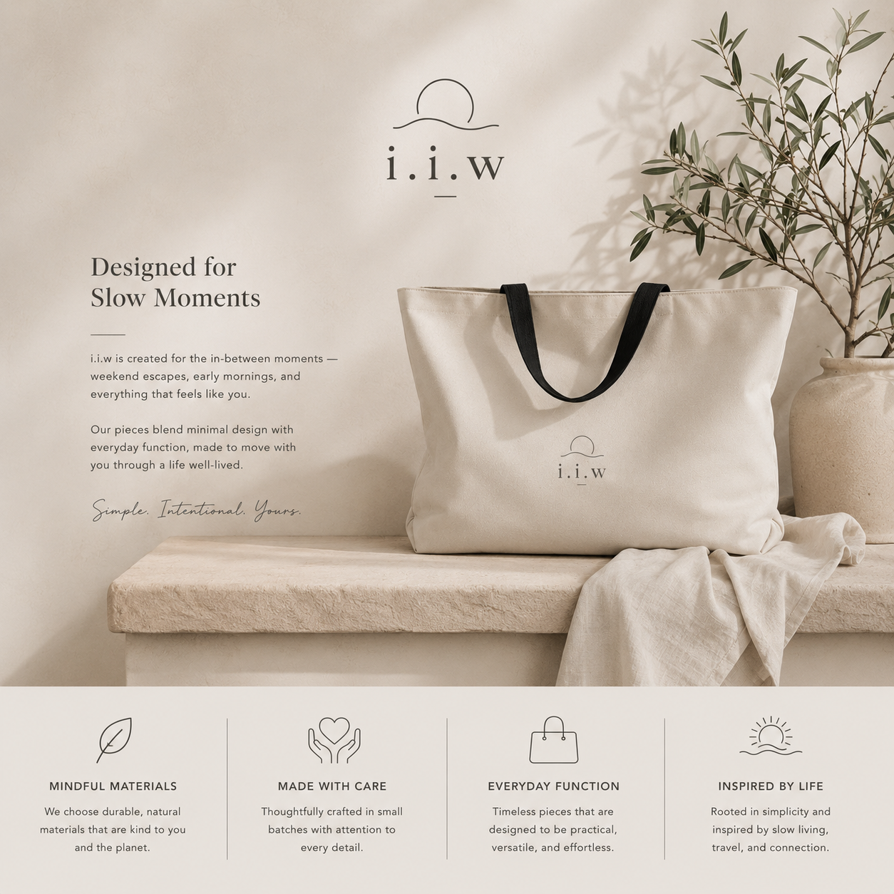 Beige tote bag with black handles on a beige couch, featuring the brand 'i.i.w'.