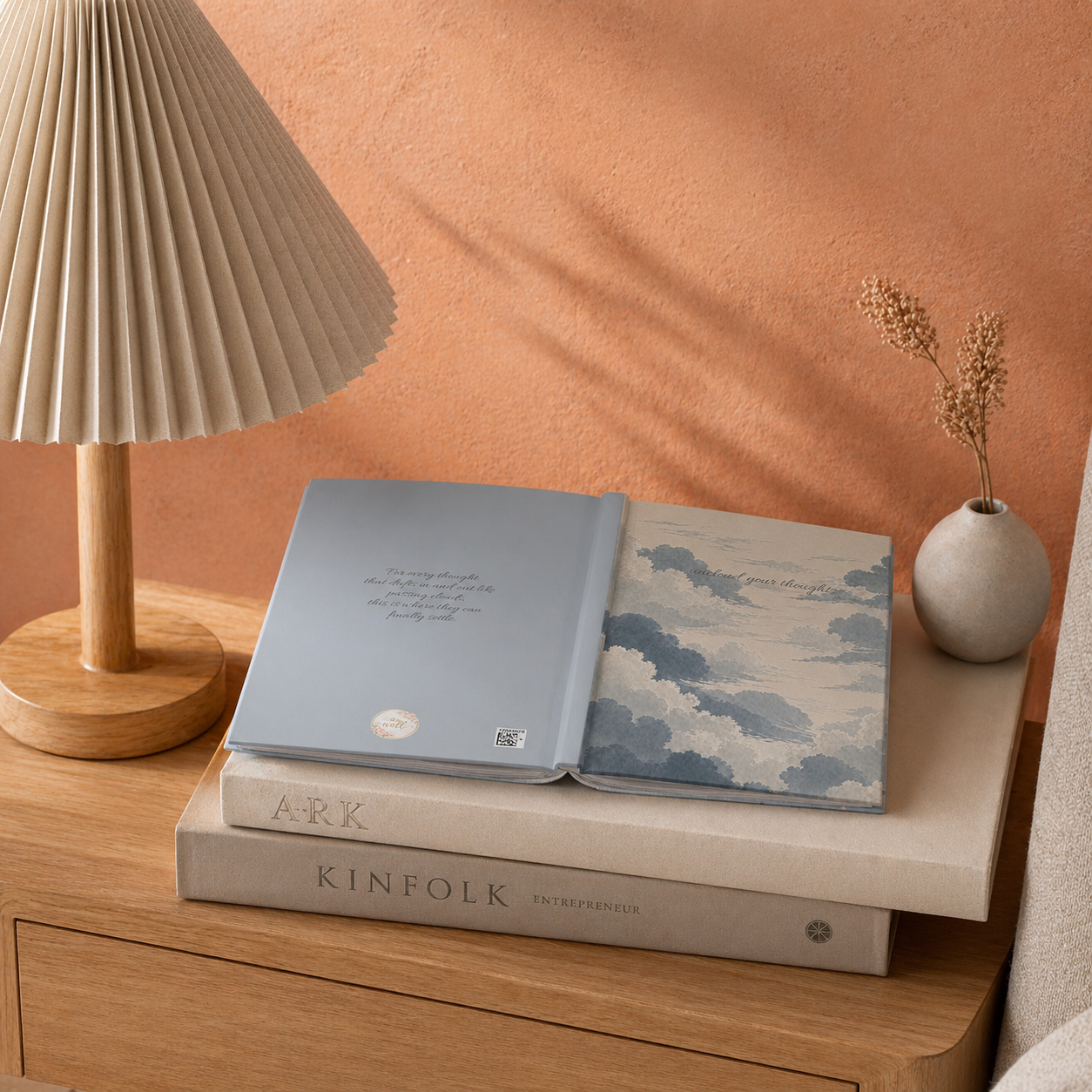 Two notebooks on a wooden surface with a lamp and decorative vase in the background.
