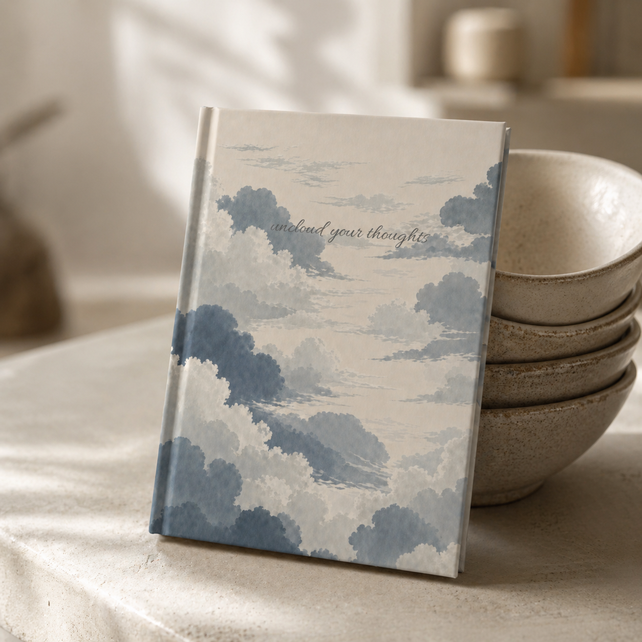 Notebook with cloud design on a surface with bowls in the background
